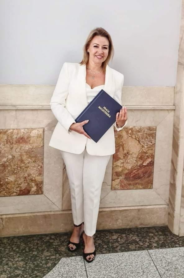 Zdjecie kobiety trzymającej pracę magisterską